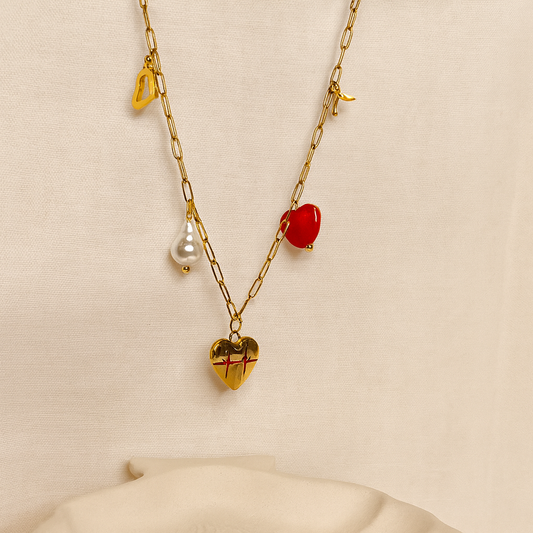 Gold chain necklace with heart-shaped pendants on a beige background