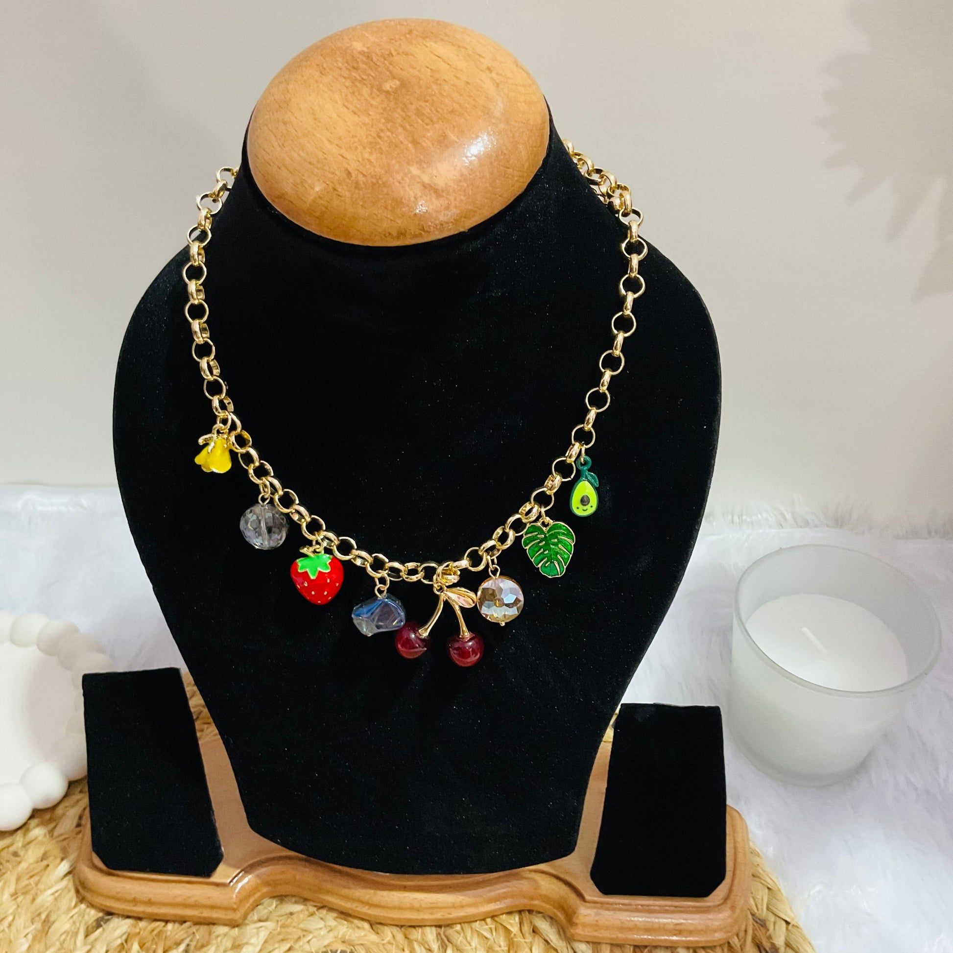 Necklace with colorful charms on a black bust against a white background