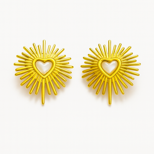 Gold sunburst earrings with heart centers on a white background