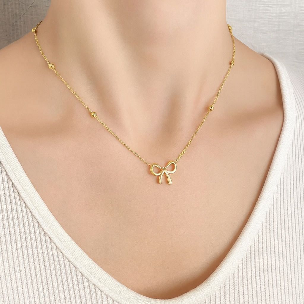 Gold necklace with a bow pendant on a mannequin
